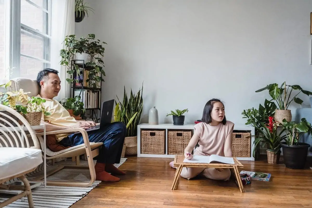Father and Daughter Working while Watching TV Together