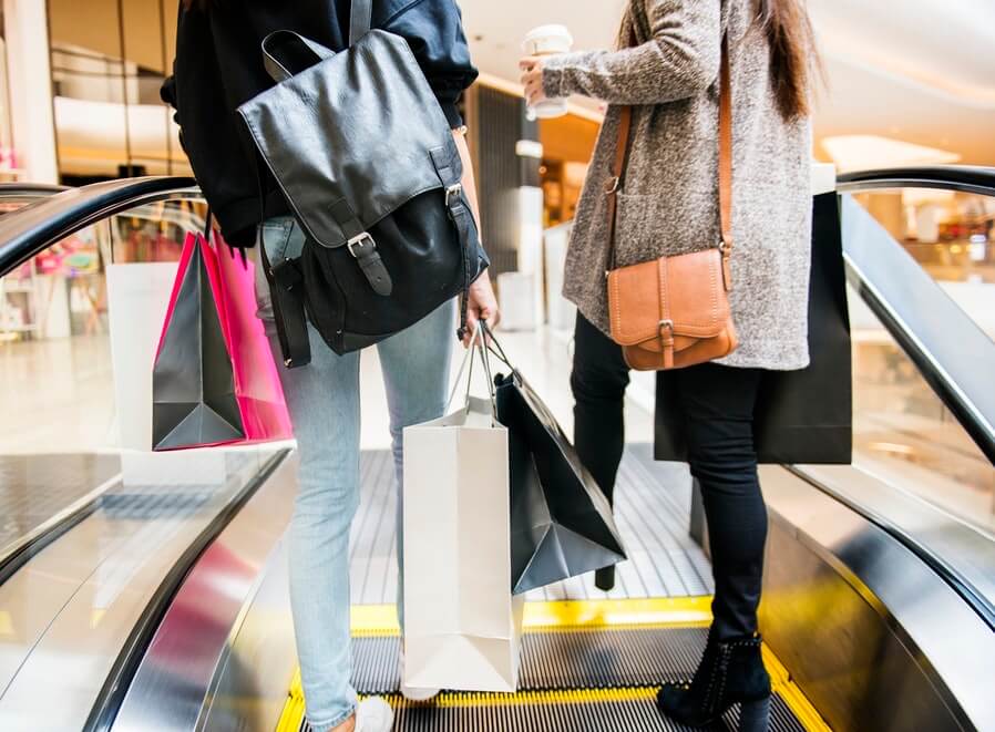 women on the shopping mall escalator