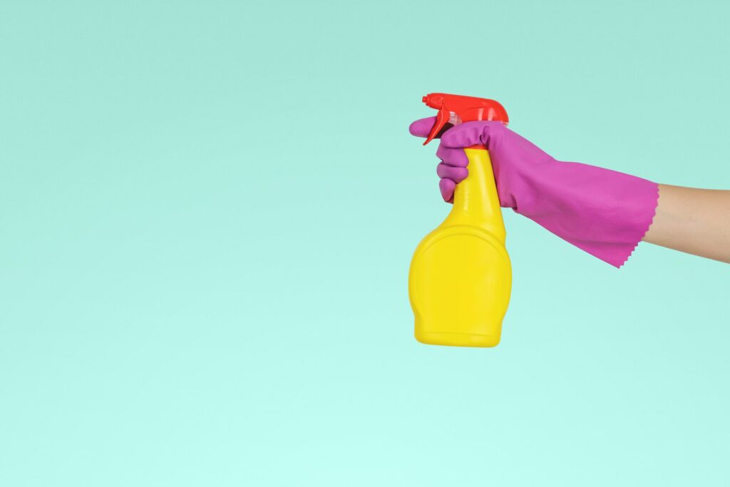 Gloved hand carrying an air spray bottle