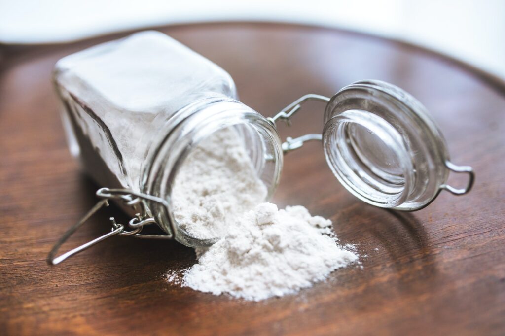 A tipped over mason jar with flour coming out