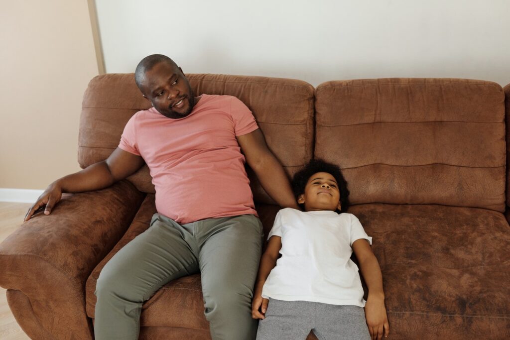 father and son relaxing on a sofa