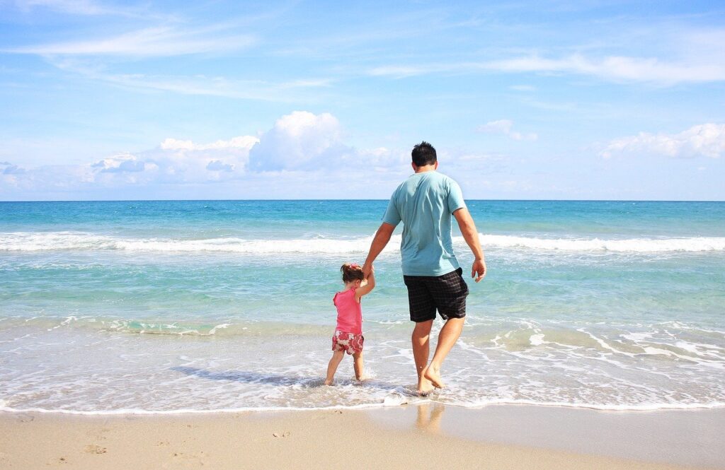 Father and child play by the beach