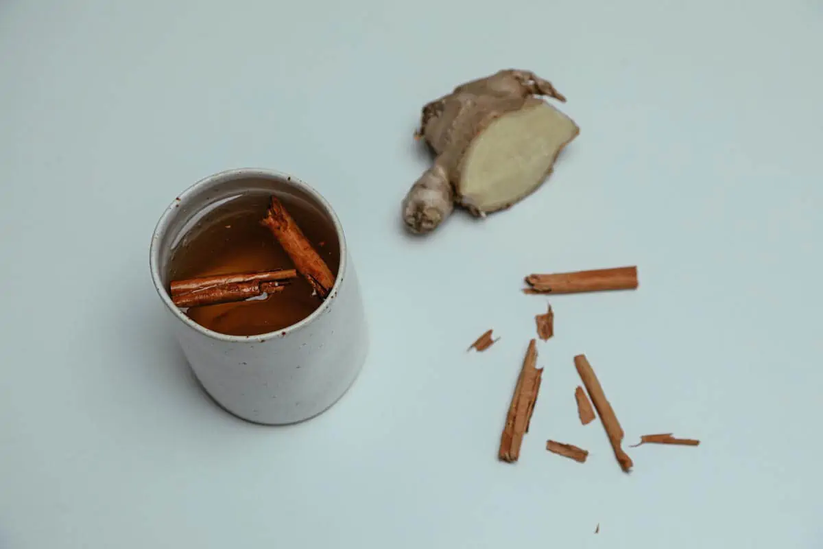 cup of ginger tea with cinnamon sticks