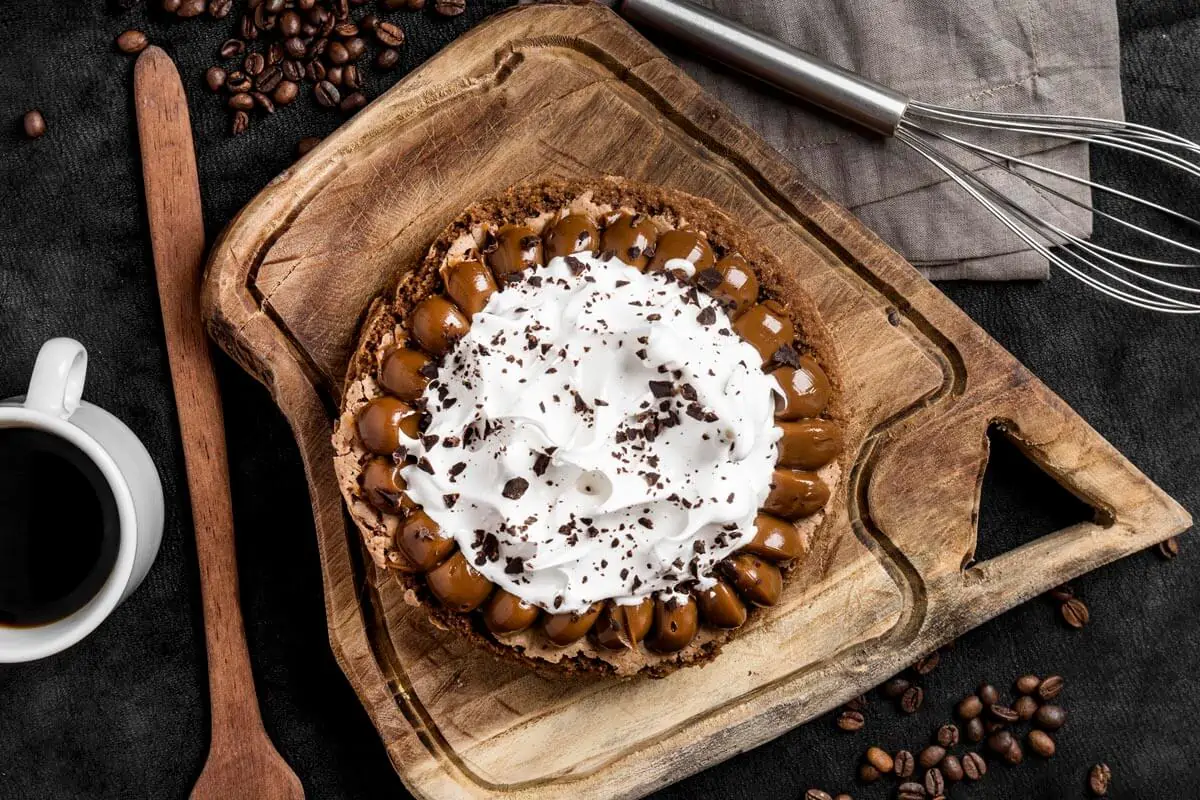 top view delicious cake with whisk coffee