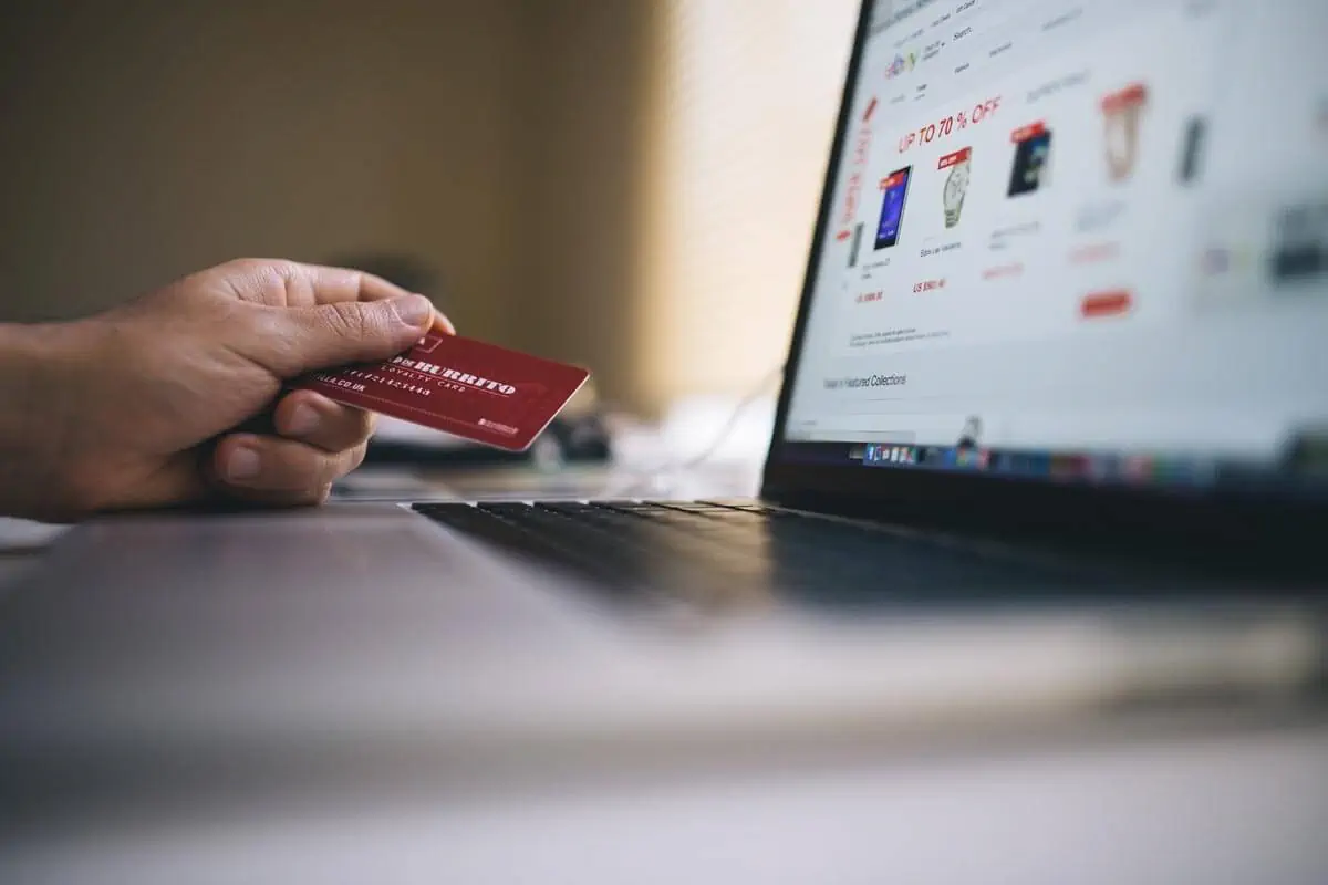 photo of hand holding card on laptop