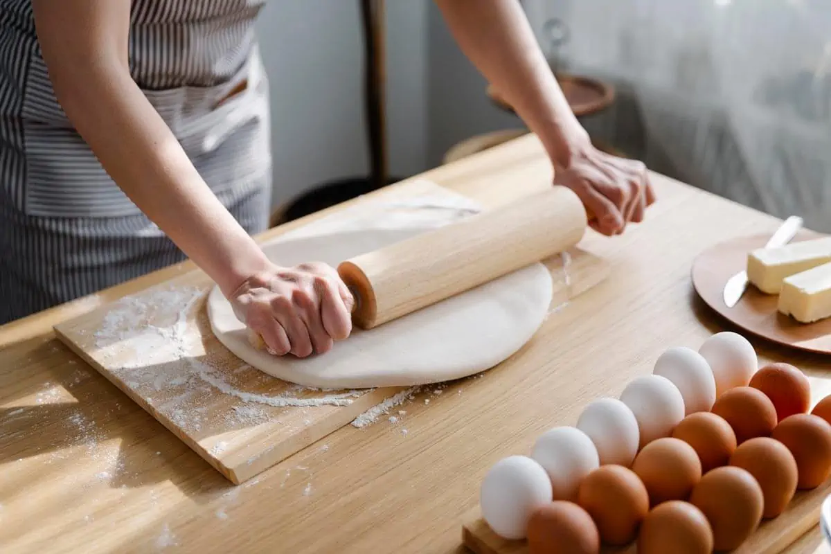 woman flats dough for baking