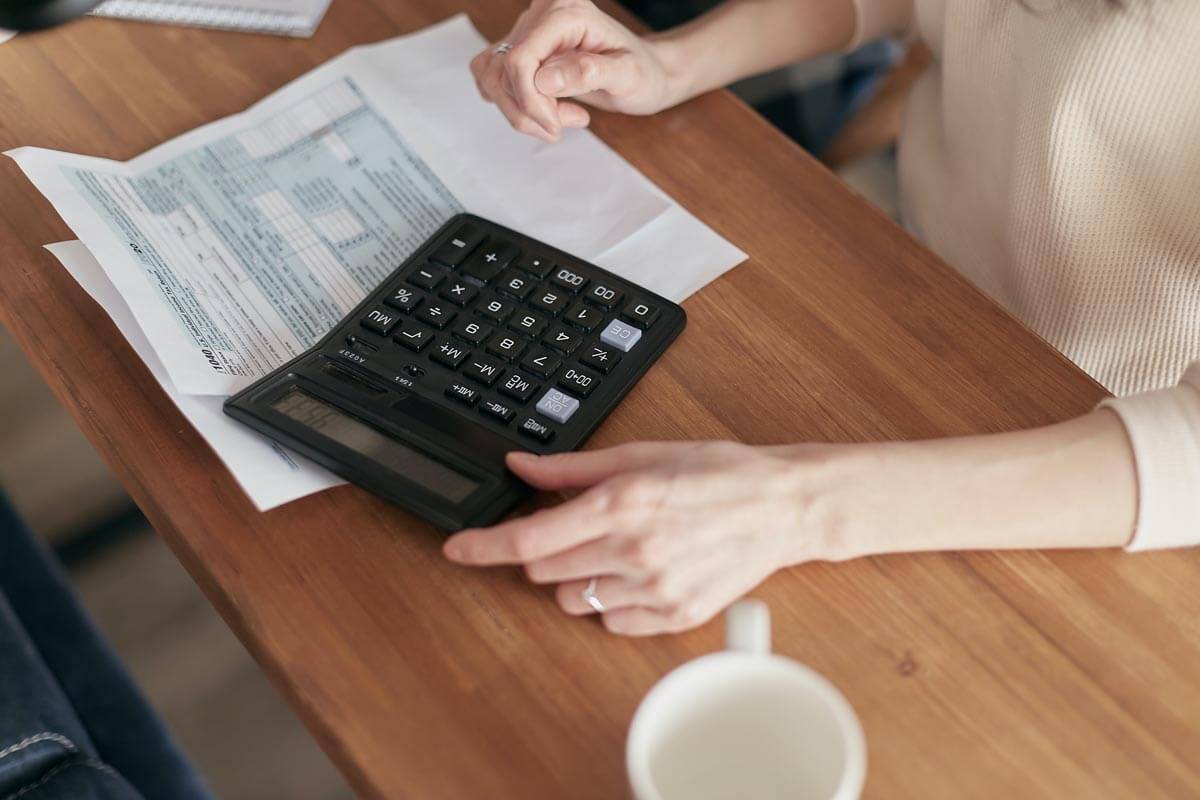 woman using calculator on a wooden table