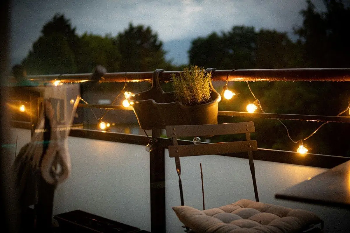 a balcony with a chair and a potted plant on it
