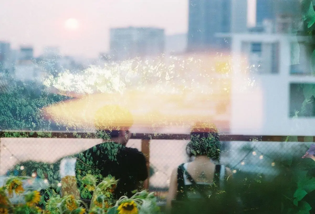 reflection of couple on balcony in window
