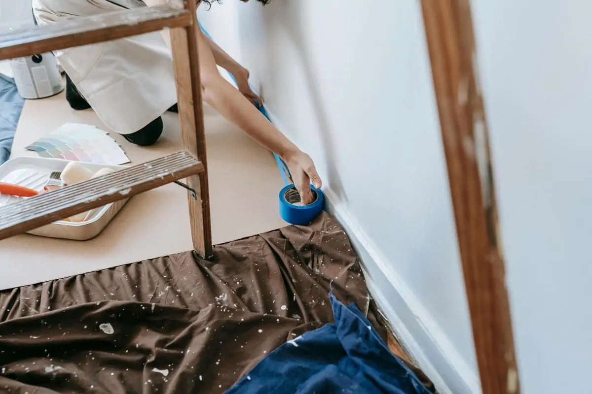 crop photo of person putting tape on wall
