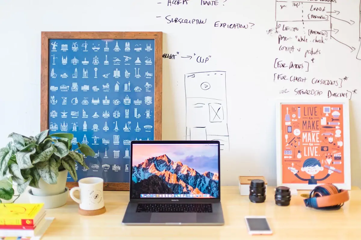 macbook pro on brown wooden table beside white mugmacbook pro on brown wooden table beside white mug