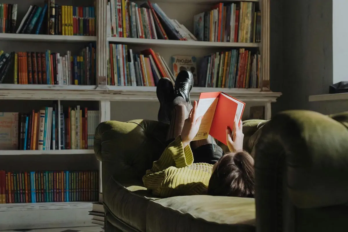 woman in black t shirt lying on yellow bed