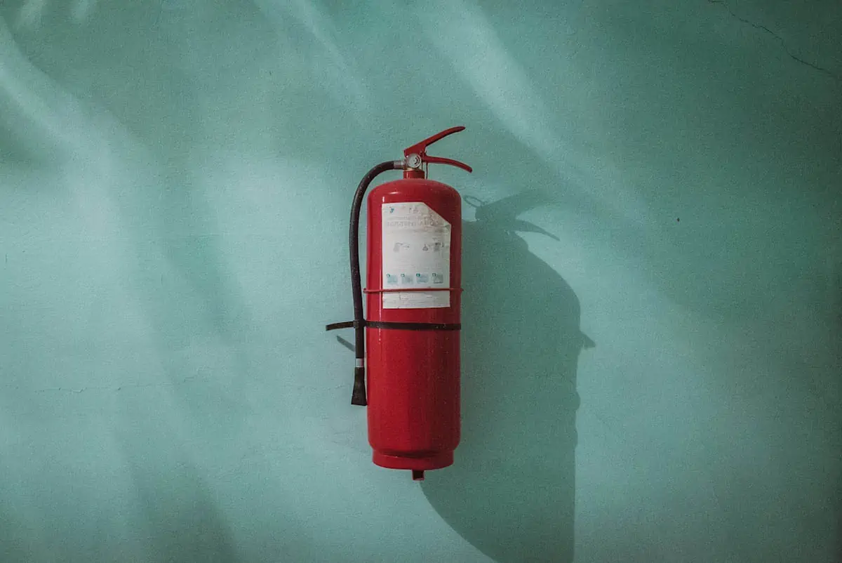 red-fire-extinguisher-on-green-wall